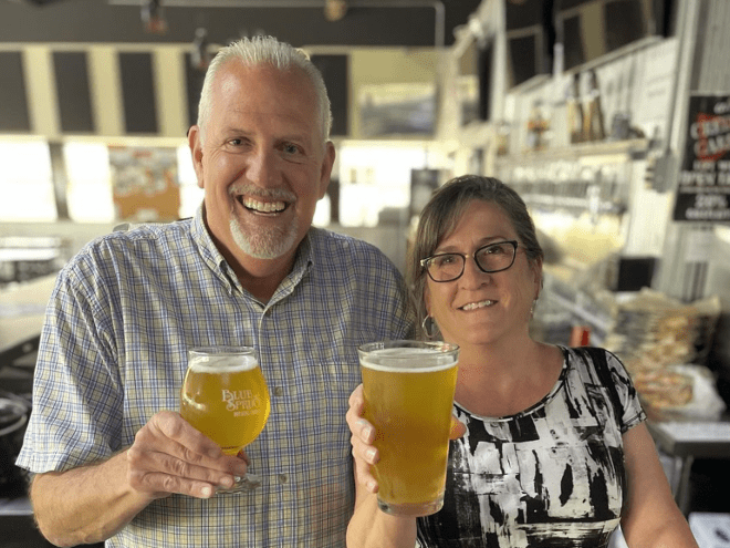 a man and a woman holding glasses of beer