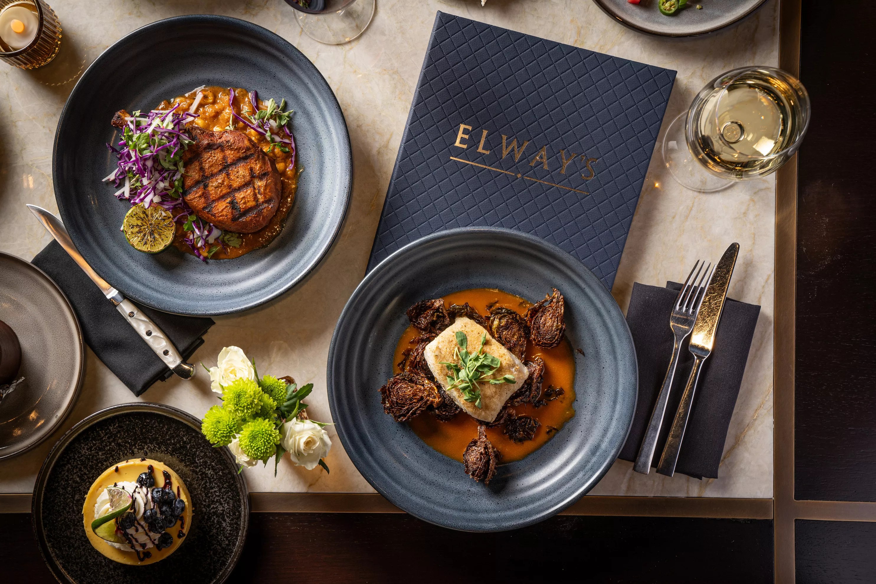 Steak, Brussels sprouts and other dishes on a marble counter