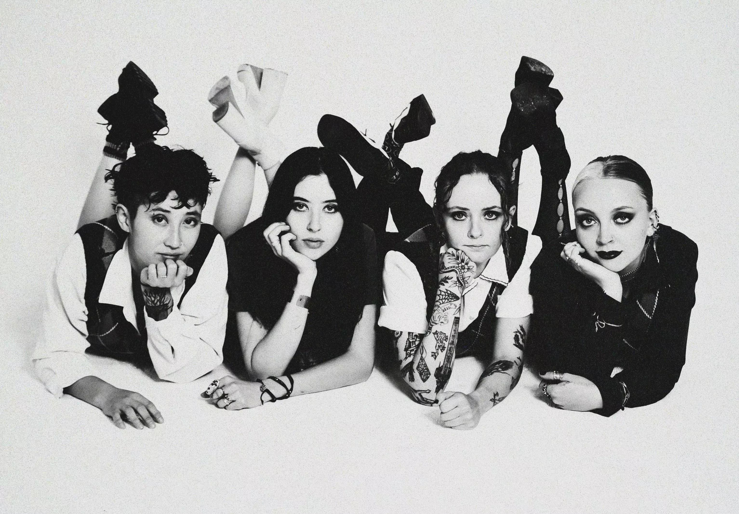 four women posing on the ground
