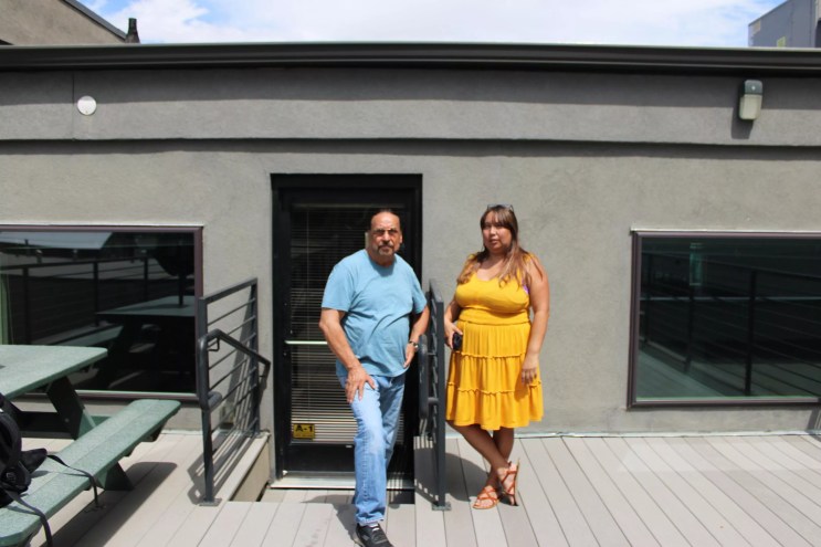 man and woman smiling outside of a building