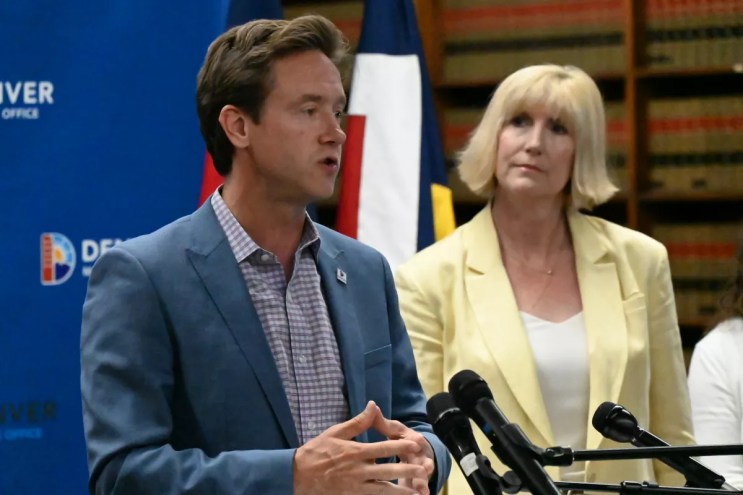 Two people stand at a lectern.