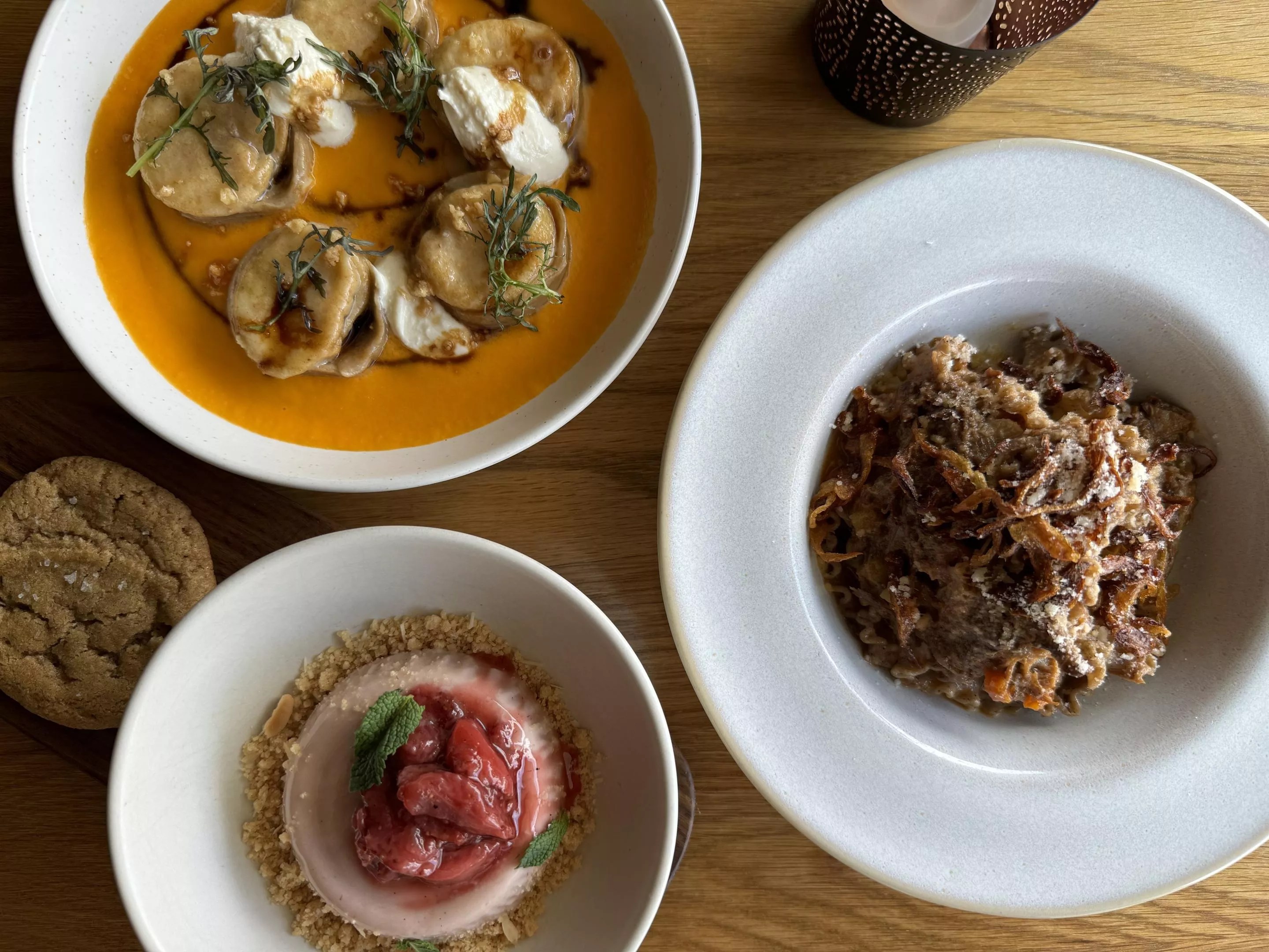 two pasta dishes and a panna cotta with a cookie