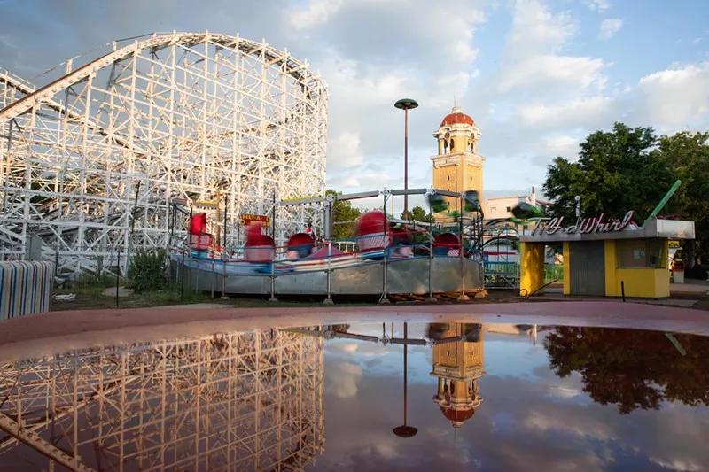 amusement park with rollercoaster over lake