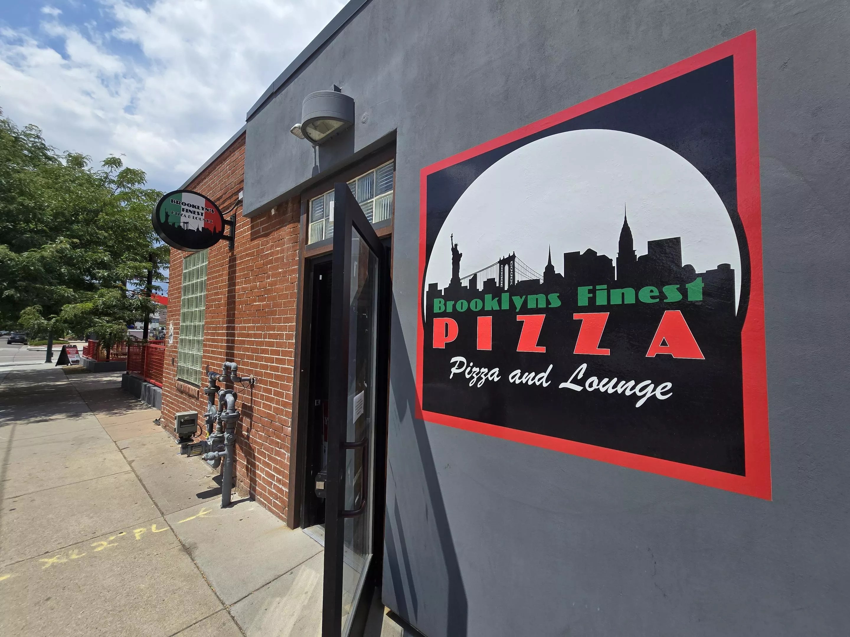 grey building with a logo for a pizza place painted on the wall