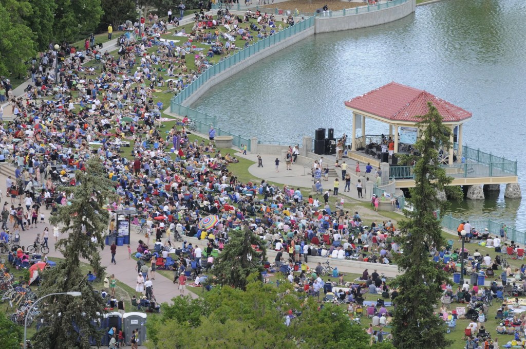 People in park by lake for a concert