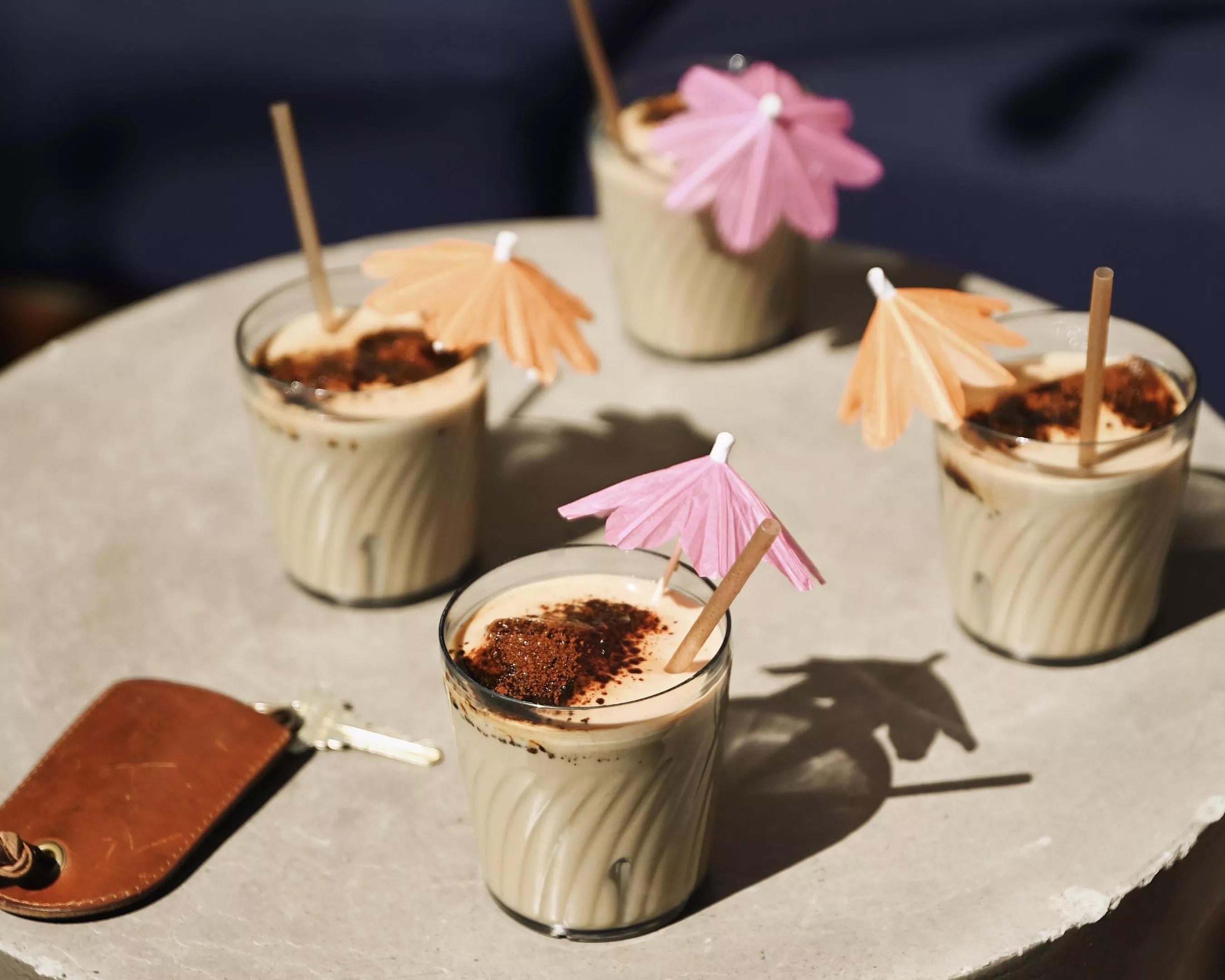 several glasses of frozen coffee drink with umbrella garnishes