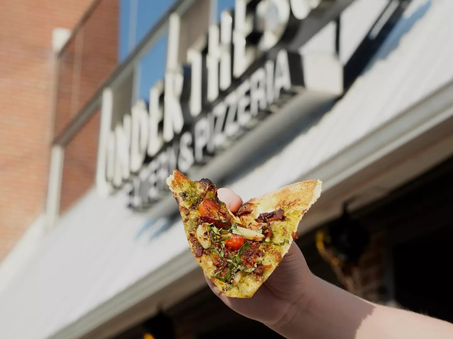 hand holding slice of pizza