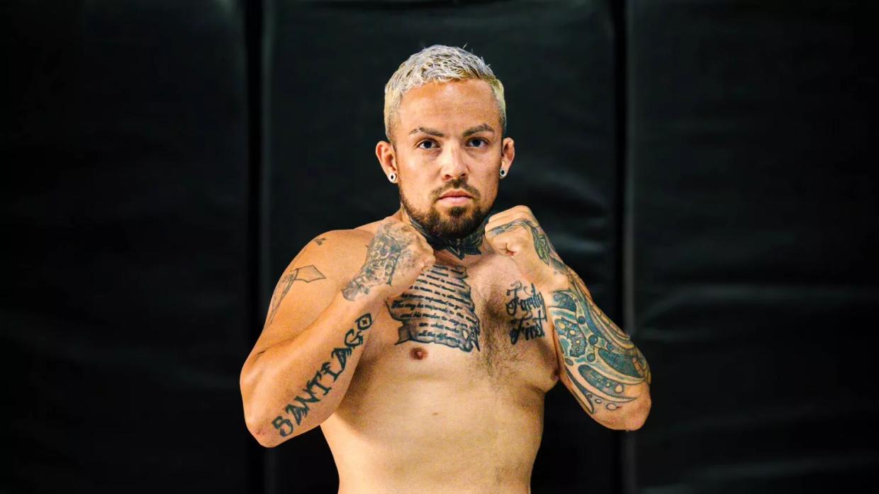 MMA fighter poses with hands up