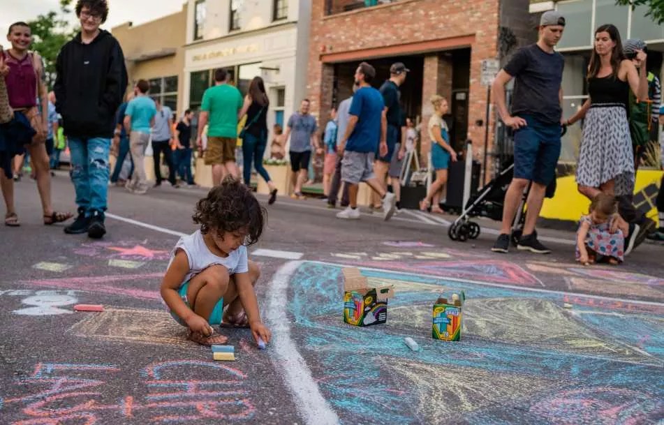 A child draws with chalk on the road
