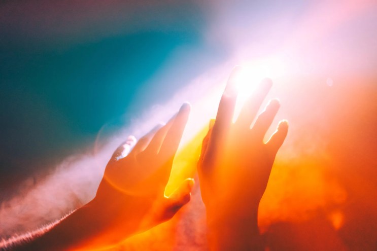hands raised to heat and sun
