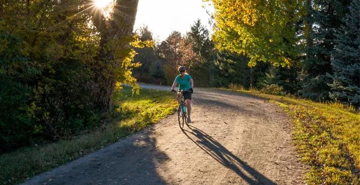 man on bicycle under fall leaves