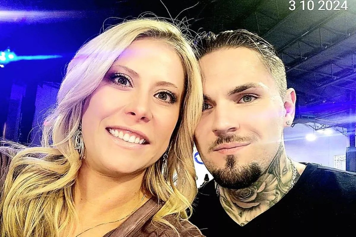 A man and a woman smile.