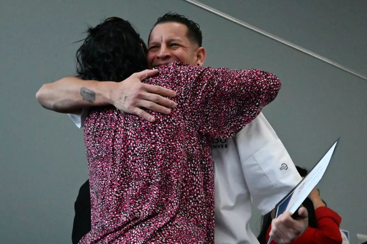 A man hugs.
