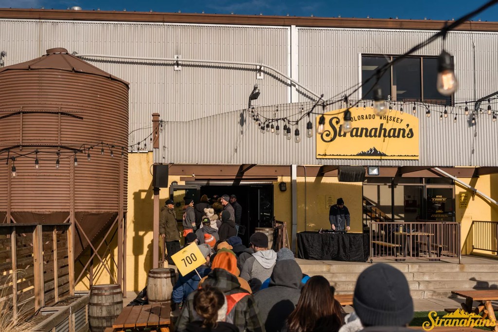 crowd lined up outside a distiller