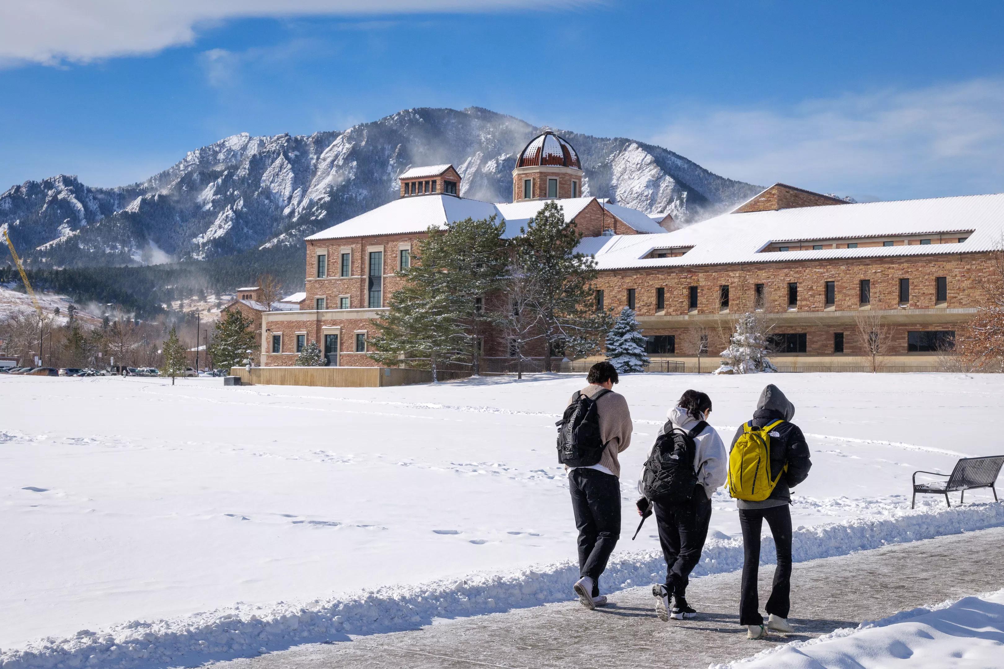 Three students walk across the University of Colorado Boulder campus on a snowy day on the first day of the 2025 spring semester.