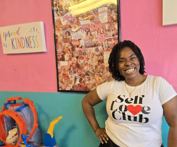 woman posing in front of a blue and pink wall