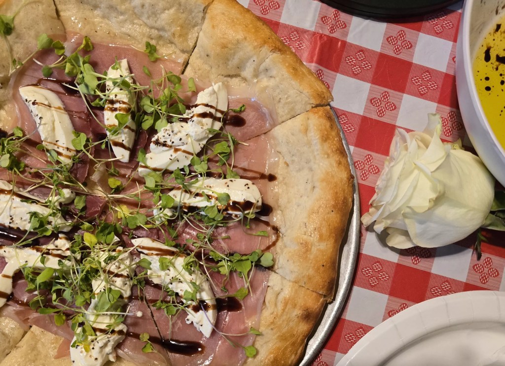 pizza topped with prosciutto and burrata