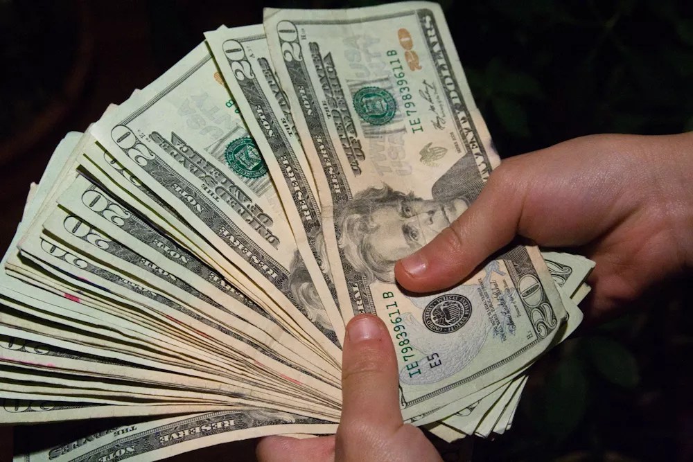 Holding a lot of $20 bills