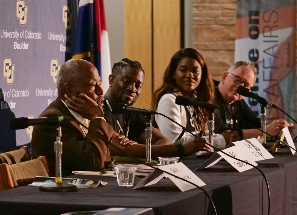 Panelists talk at a table
