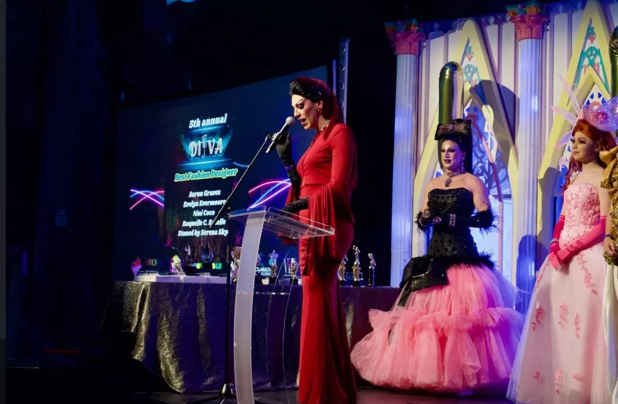 drag queens stand on a stage