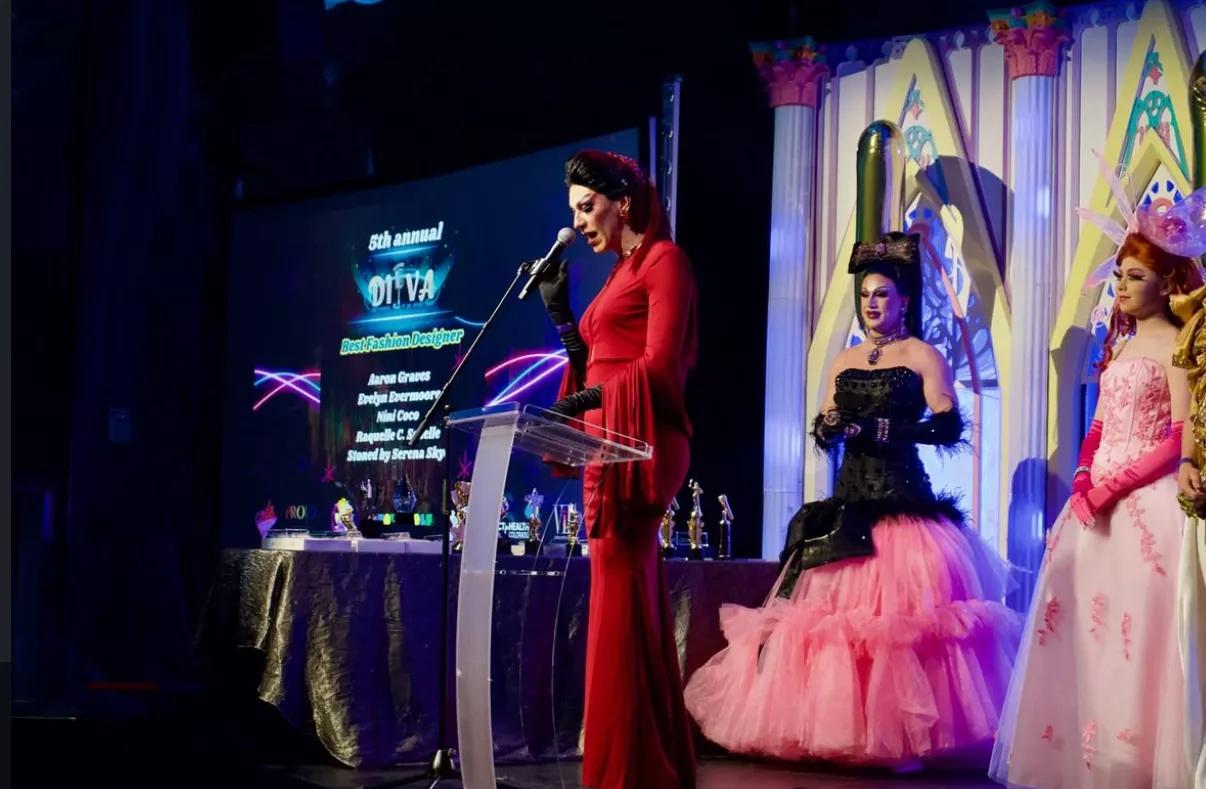 drag queens stand on a stage
