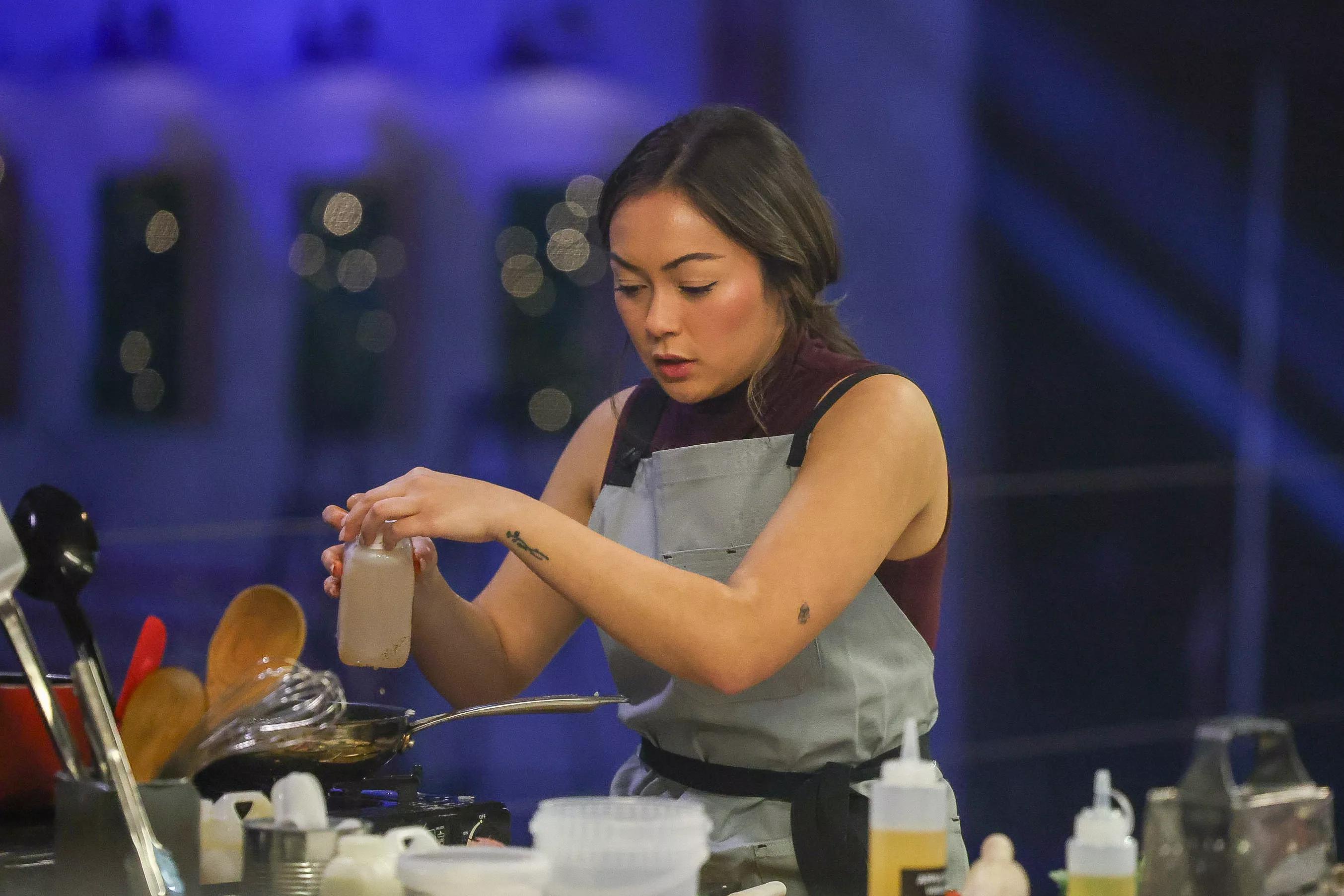 A woman cooks in a kitchen.