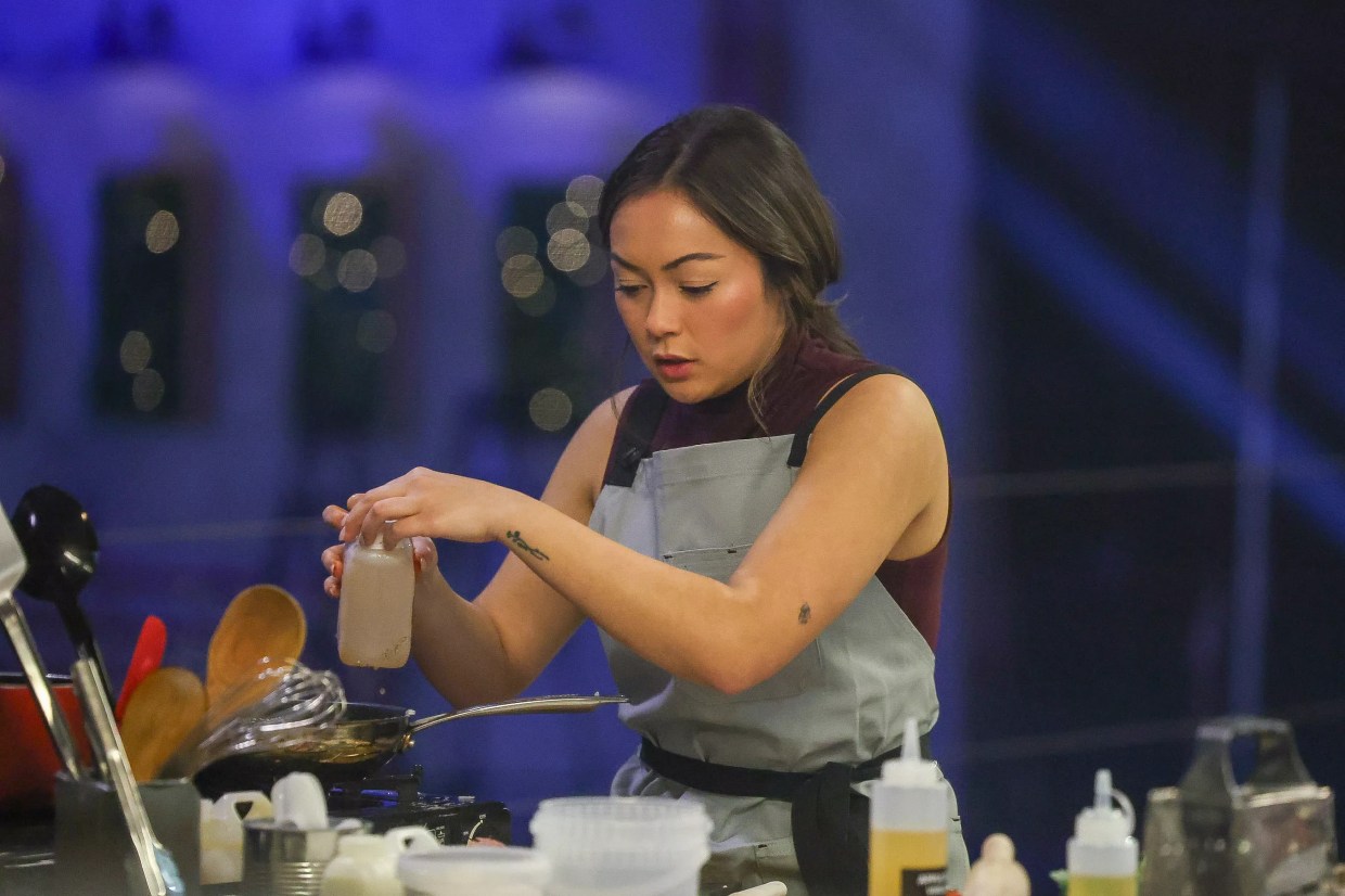 A woman cooks in a kitchen.