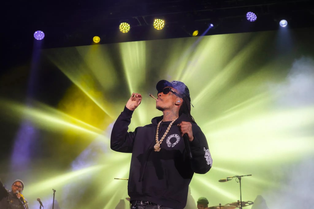 A photo of Wiz Khalifa on stage at Red Rocks smoking a joint.