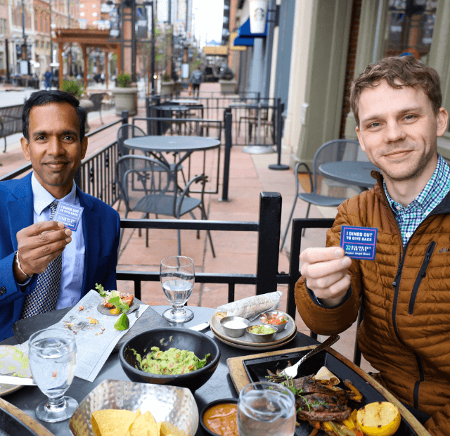 two men at outdoor restaurant.