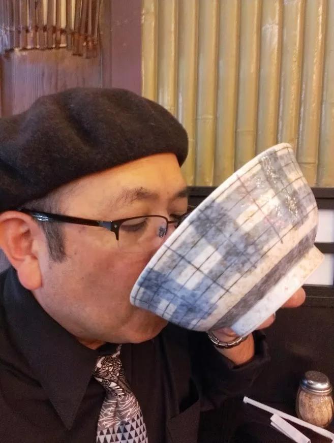 man in beret slurping ramen