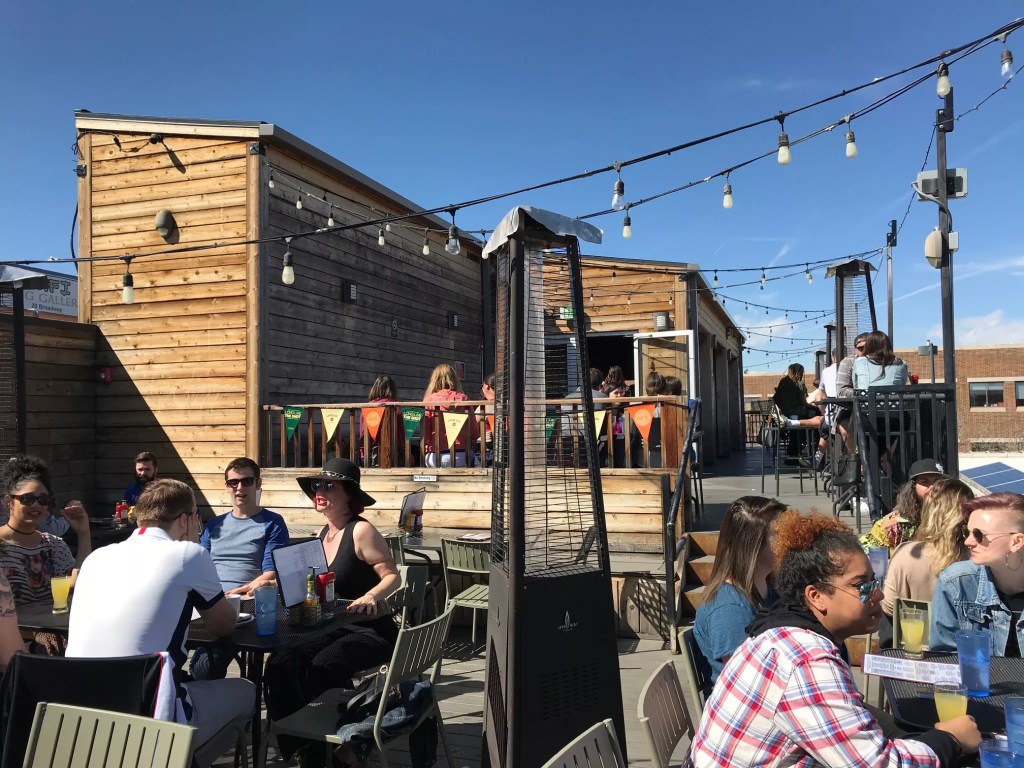 people sitting on a rooftop patio