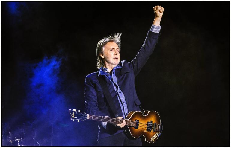 Paul McCartney with a guitar on stage