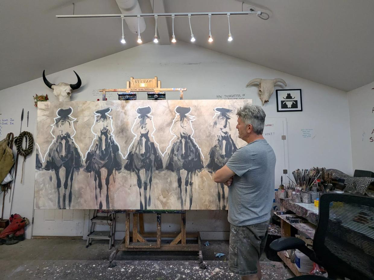 A man looks at his artwork