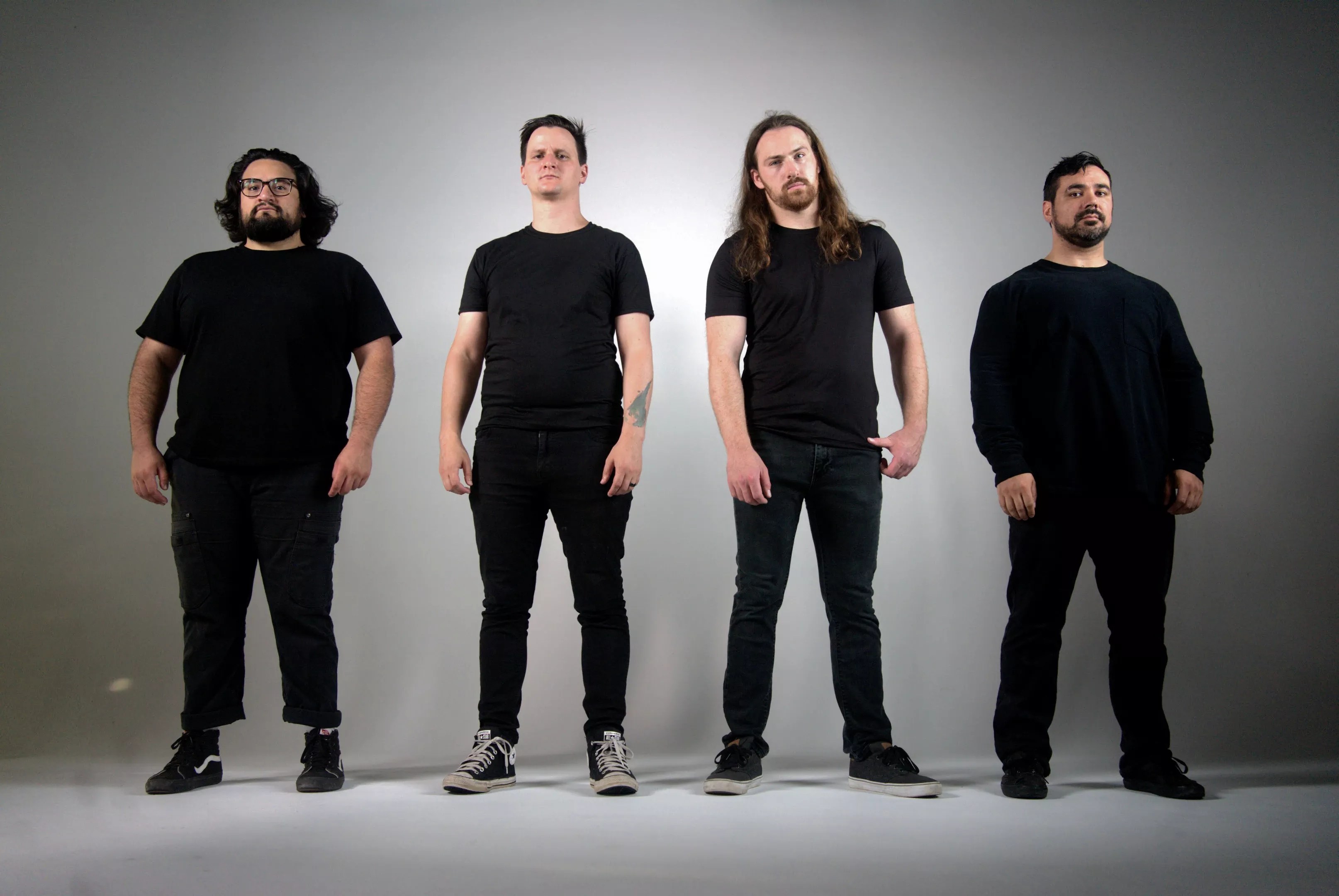 four men in black t shirts and jeans