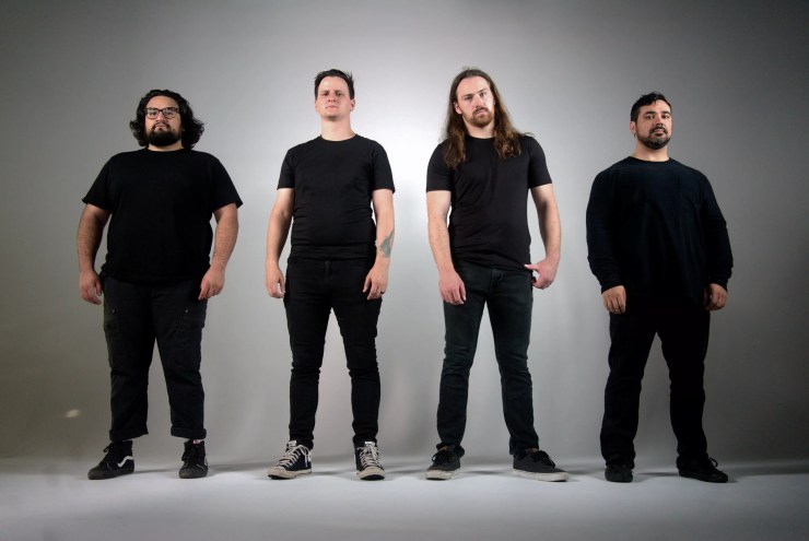 four men in black t shirts and jeans