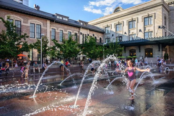 kid plays in splash fountains