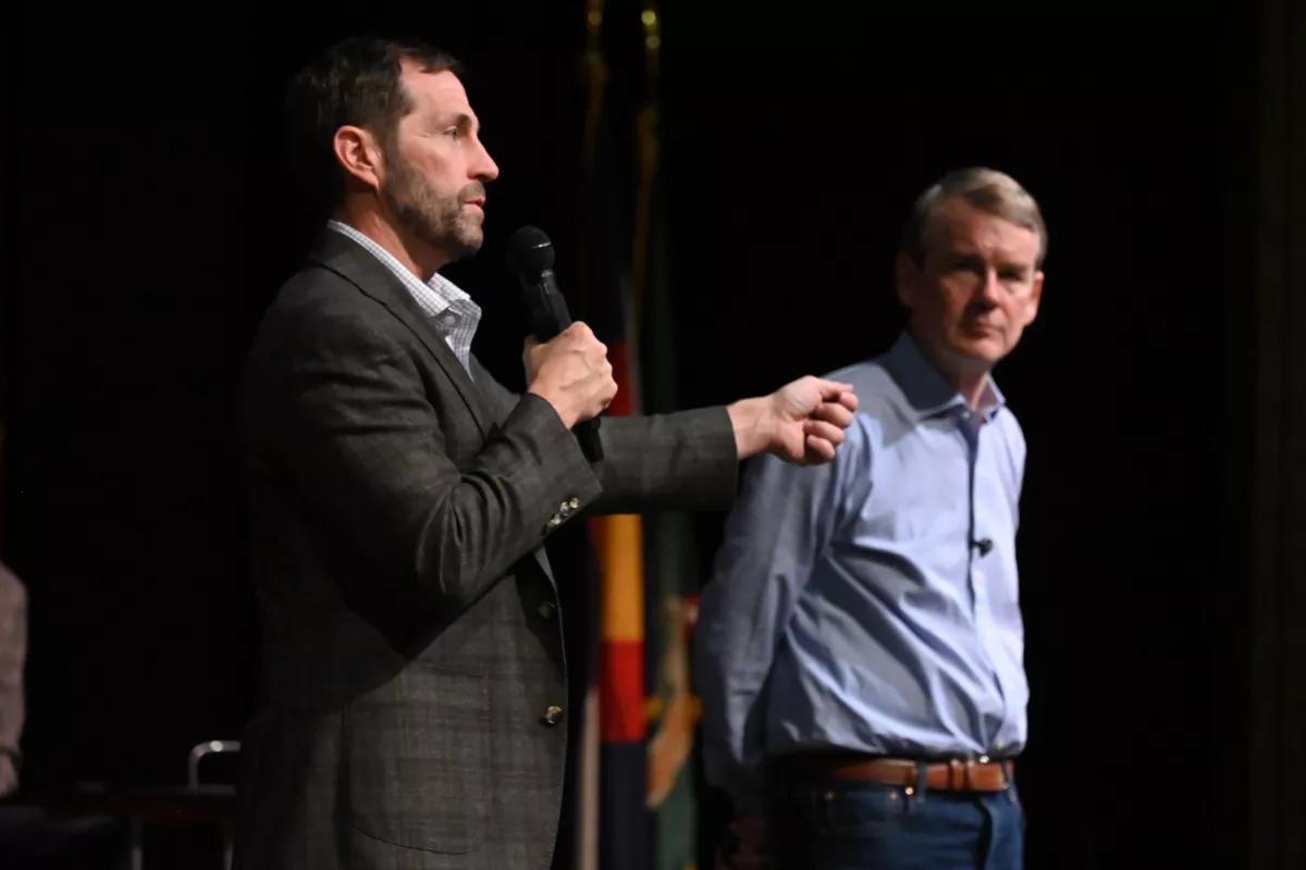 Two guys talk on stage.