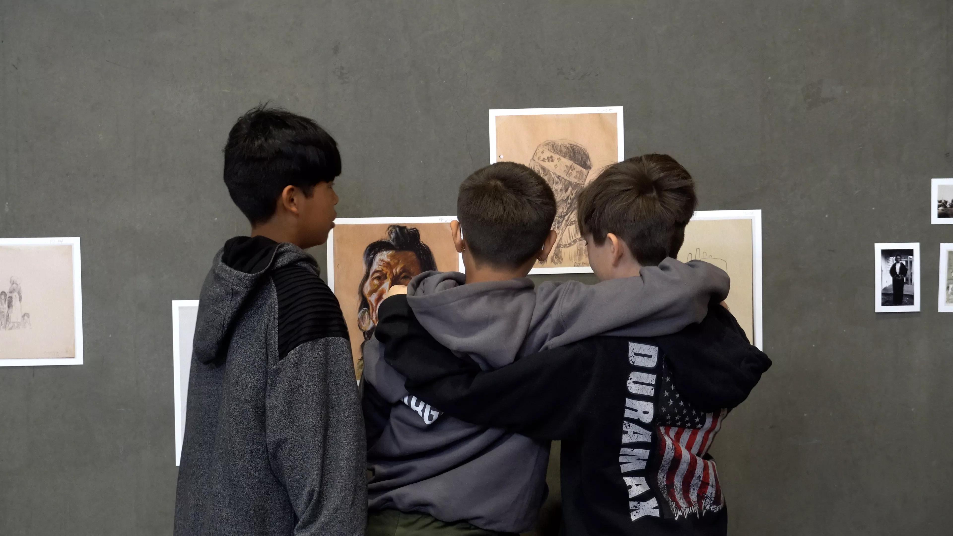 Kids gather around art.